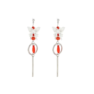 Detail of silver butterfly earrings with red teardrop pearls and long tassels