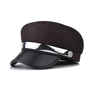 Detail of dark brown fabric and black leather brim on nautical baker boy hat with metal M bar