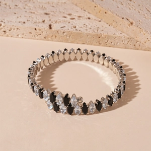 Détail de zircons en forme de goutte noirs et blancs sur un collier ras du cou