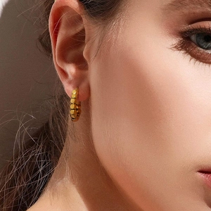 Minimalist 18K gold stainless steel geometric hoop earrings worn by a female model