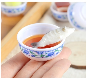 Detailed macro view of a miniature fish soup bowl with blue floral ceramic patterns