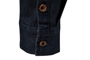 Detailed close-up of dark denim shirt cuffs featuring double stitching and brown buttons