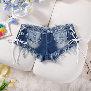 Dettaglio di hot pants in denim blu scuro con lacci laterali e bordi sfrangiati