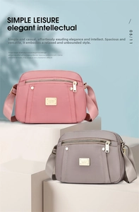 Detail of pink and grey nylon crossbody bags with metal logo on minimalist podium