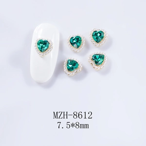 Gros plan de charms pour ongles cœur vert émeraude 7,5x8mm avec perles et base dorée