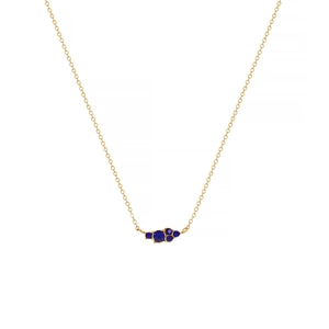 Detail of gold chain necklace featuring a cluster of five faceted blue gemstones