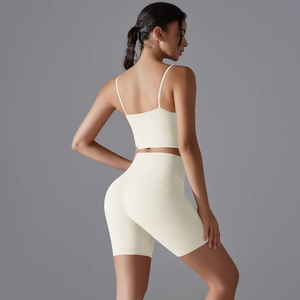 Vista posteriore del set yoga bianco crema con reggiseno sportivo e pantaloncini a vita alta