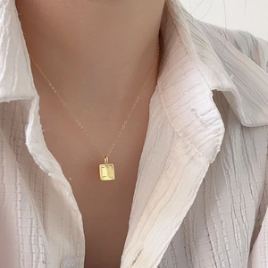 Elegant 925 sterling silver square pendant necklace in gold worn by a model