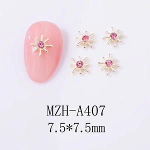 Macro shot of 7.5x7.5mm gold star nail charms with pink rhinestones for DIY nail art