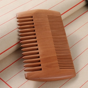 Double-sided peach wood beard comb with fine and wide teeth on textured background
