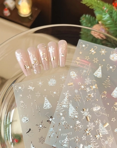 Close-up of gold and silver Christmas nail stickers with snowflakes and reindeer motifs