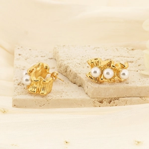 Boucles d'oreilles vintage dorées à la forme ondulée avec des perles blanches élégantes
