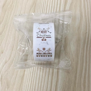 Close-up of a roll of Merry Christmas adhesive stickers in transparent packaging