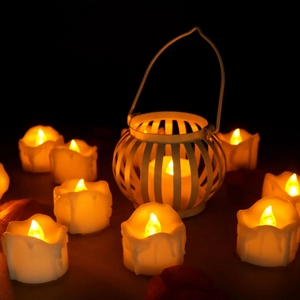 Close-up of LED tea lights with warm yellow glow and a decorative white wire lantern