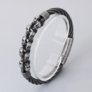 Detail of retro skull steel wire bracelet with antique silver finish and woven texture