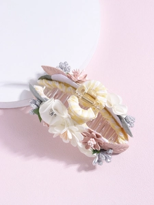 Detail of fabric flower shark clip with plaid patterns and delicate 3D floral accents