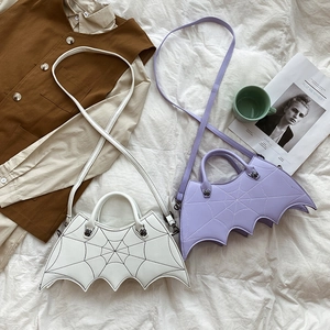 Detail showing two bat-shaped PU leather bags in white and lilac with spiderweb embroidery