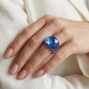 Close-up of a large blue faceted crystal stone set on a minimal silver stainless steel ring