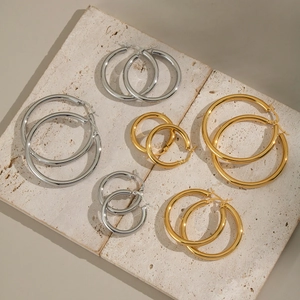 Minimalist stainless steel hoop earrings in gold and silver finish on stone plates