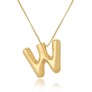 Macro shot of 3D balloon style golden letter W pendant with mirror reflection on white