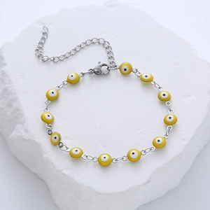 Detailed close-up of yellow Evil Eye charm bracelet with stainless steel lobster clasp