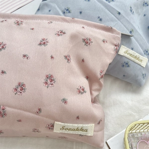 Close-up of floral fabric makeup bags in pink and blue with premium Sozakka gold embroidery