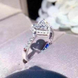 Macro shot of a luxury heart-shaped zircon ring with halo setting in a silk gift box