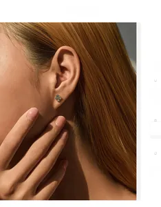 Gros plan d'une boucle d'oreille trèfle en argent S925 avec zircons scintillants