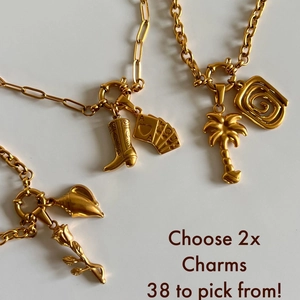 Flat lay of gold stainless steel necklace with cowboy boot and poker charms
