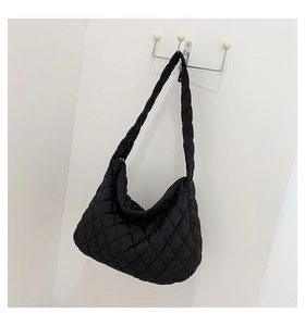 Detail of a large black quilted cloud bag made of lightweight nylon with soft pleated texture