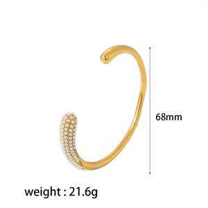 Detailed view of a gold-plated stainless steel cuff with white pearls, 68mm diameter