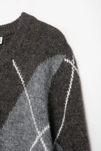 Close-up of the diamond knit pattern and plush texture on this brown round neck sweater