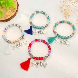 Boheemse kralenarmbandenset met turquoise kralen, kwastjes en etnische bedeltjes op beige