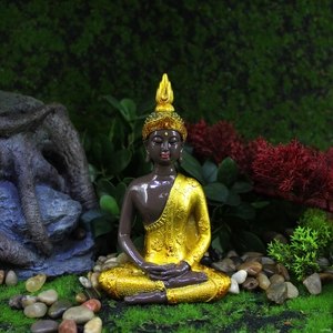 Zen Buddha statue figurine in resin with golden robe sitting on moss for home decor