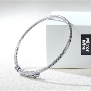 Detail of silver twisted rope textured stainless steel cuff bracelet with mirror finish