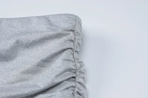 Gros plan sur la maille gris chiné et les détails froncés par cordon de serrage