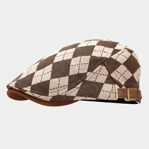 Detail of diamond check flat cap showing woven texture and adjustable side buckle strap