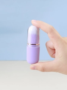 Detail of portable lavender capsule makeup brush with synthetic bristles and clear cap