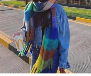 Detailed close-up of rainbow plaid scarf with soft fringe and thick winter texture