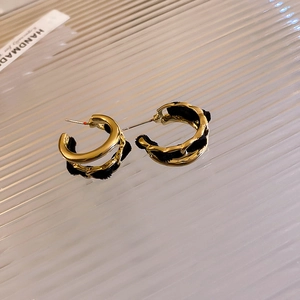 Detailed view of handmade double-layered C-shape earrings with black velvet and gold metal