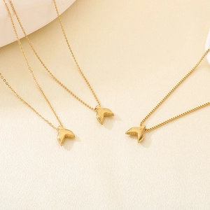 Detail view of gold fishtail pendant showing ball, O-link, and box chain styles