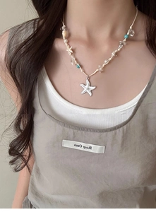 Detailed shot of ocean style cord necklace with white starfish pendant and pearls