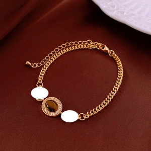 Detail of gold plated bracelet with brown tiger eye stone and zircon accents