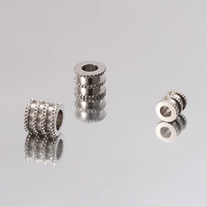Three silver stainless steel textured beads displayed on a gray reflective background