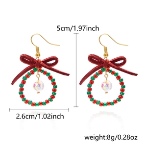 Detailed view of Christmas bow earrings with red beads and faceted crystal pendant