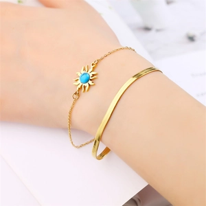 Detail of 18K gold double layer bracelet with sun pendant and blue stone inlay