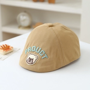 Detail of khaki cotton baby beret featuring embroidered letters and 3D bear patch