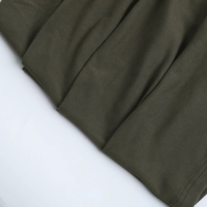 Gros plan du tissu olive de la robe montrant une maille de qualité et des coutures fines