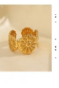 Macro shot of gold floral daisy open ring on beige silk background showing premium texture