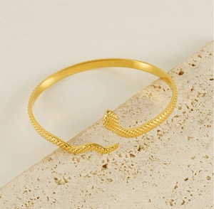 Detail of 18k gold snake bracelet showing intricate scale texture on stainless steel